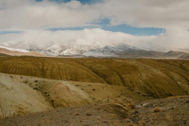 snowy mountains behind formation of hills